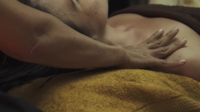 Thai masseuse massaging her shoulders to a girl