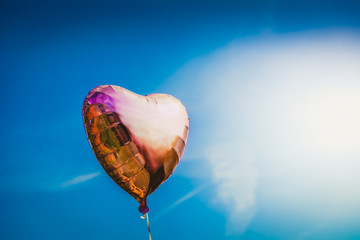 Fototapeta na wymiar Heart shaped ballon on the sky background