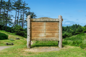 Wooden blank billboard with empty space in a park on a sunny day, Oregon, usa.