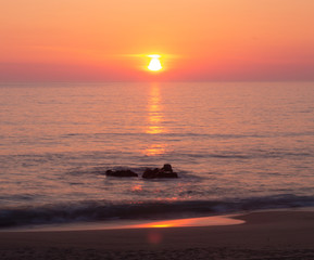 Pink Reflection on Rock Formation at the Shoreline