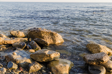 Fototapeta na wymiar Sea waves are fighting against the big rocks on the shore.
