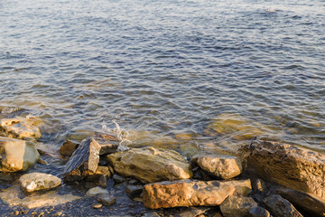 Obraz premium Sea waves are fighting against the big rocks on the shore.