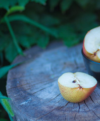 cut pear in half against the background of a tree