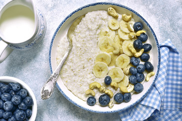 Oat porridge with banana, nuts  and fresh blueberry.Top view.