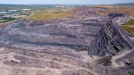 Aerial drone view of a huge opencast coal mine cut into a rural hilly area (Dowlais, Merthyr Tydfil, Wales)