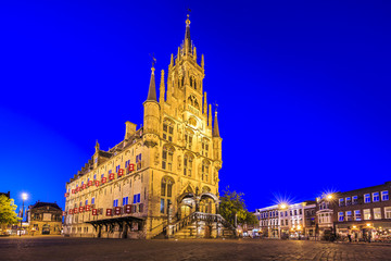 Fototapeta na wymiar Monumental gothic City hall on the square of historical city Gouda illuminated during dusk