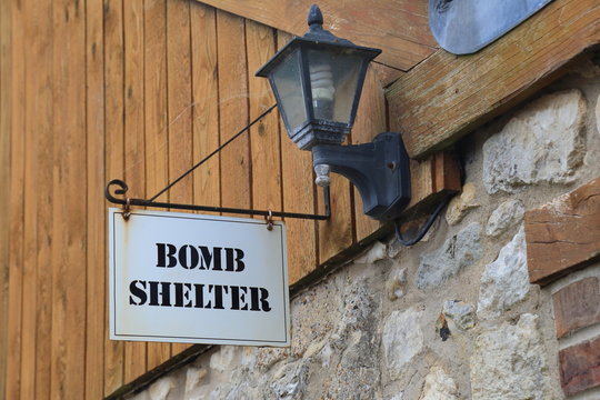 Bomb shelter sign on the wall in village of Beer in East Devon