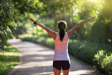 Healthy woman outstretched arms on morning park