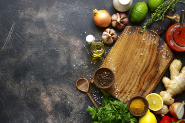 Fototapeta na wymiar Food background with empty wooden cutting board and ingredient for cooking : vegetable,spices, ,salt, herb, sauce, citrus fruits.Top view with copy space.