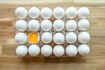 Eggs -- a still life of an egg carton with 1 egg open (egg yolk)