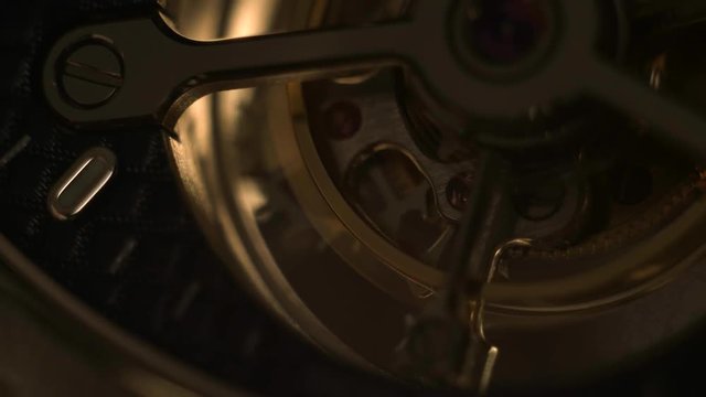 Mechanism of a watch with jewels. Open clockwork and fragments of shiny gears. Close up 4k macro shot. Time and work concept.