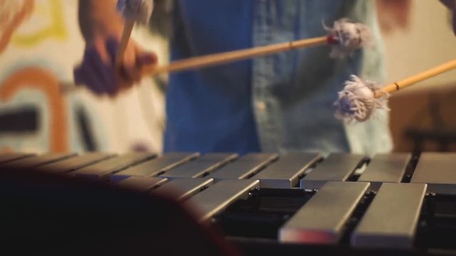 A student playing vibraphone at a music festival. The music he is playing is jazz.