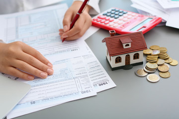 Young female calculating taxes at table, closeup
