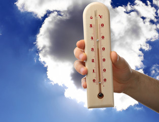 Man holding thermometer and sky on background. Hot summer weather