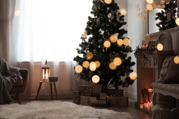 Stylish living room interior with decorated Christmas tree and blurred lights in foreground