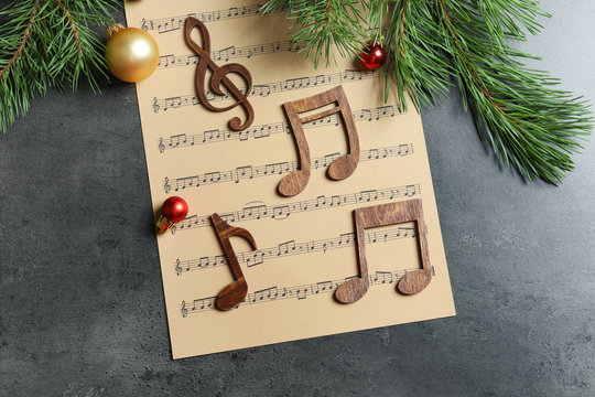 Flat lay composition with decoration and music sheet on table. Christmas songs concept