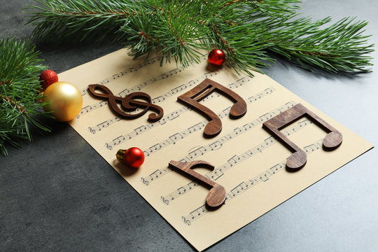 Composition with decoration and music sheet on table. Christmas songs concept