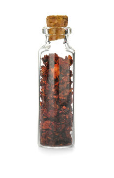 Glass bottle with spice on white background