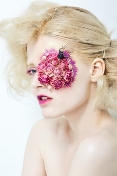 Blond young girl with flowers on face.