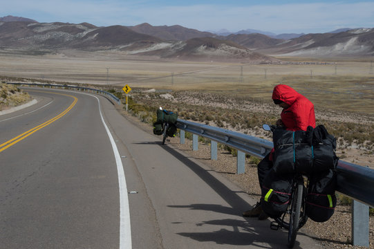 traveler in bibicleta resting on highway in bolivia