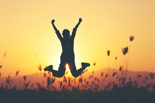 Freedom and adventure - woman happy at meadow . Free cheering girl with arms raised enjoying serene sunset in winning pose with arms stretched.