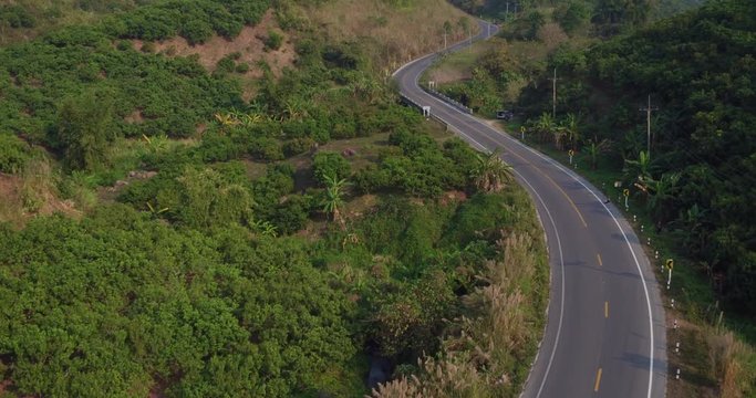 A Ducati Multistrada 1200 (2016 model) motorcycle being ridden through the countryside of Chiang Rai, Northern Thailand. Beautiful jungle scenery lines the roads.