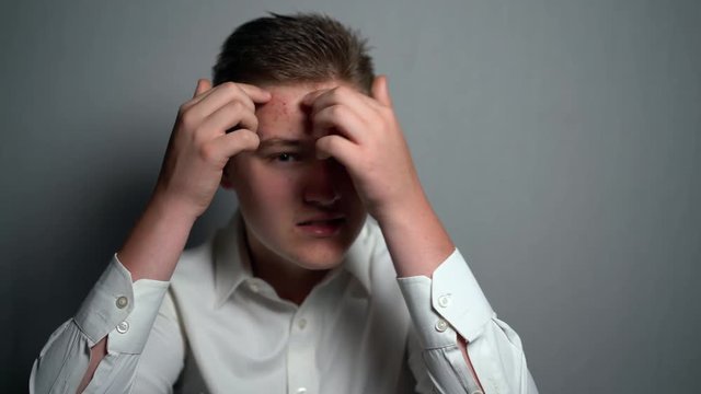 Boy with allergy rubbing his face, allergic man . Unhappy teenager with problematic skin. Healthcare and medical concept.