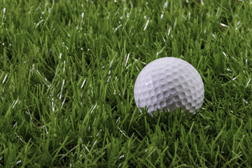 White Golf ball on synthetic artificial turf. Sport outdoor.