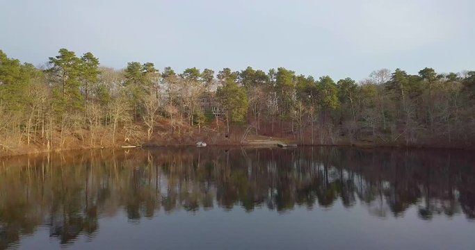 A sweeping shot of a coastal New England home complete with a quaint pond, dock, and cranberry bogs behind the property. Water towers can be seen in the distance. Shot in 4k on a DJI Mavic Pro.