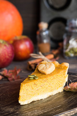 Traditional homemade American pumpkin pie with a decor of a cookie in the form of leaves for a holiday