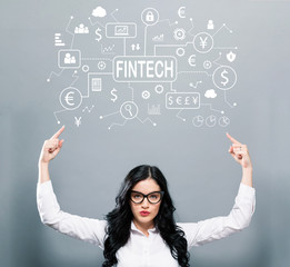 Fintech theme with business woman pointing upwards on a gray background