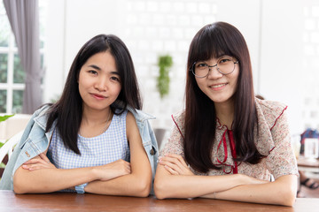 Two asian girl teen sitting together look and smile friendship or lesbian concept.