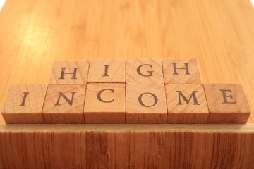 Wooden Text Block of High Income.