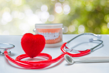 Red heart and health care equipment, teeth and mouth on the background green blurred.