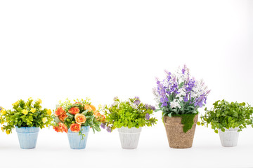 Rows of colorful fake flowers on white background, made from cloth and plastic for decoration