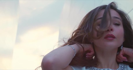 Close up of beautiful girl tossing hair backward in slow motion at sunset