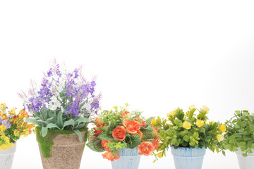 Rows of colorful fake flowers on white background, made from cloth and plastic for decoration
