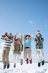雪原でジャンプをする若者たち