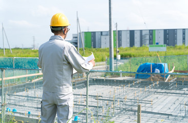 図面を持つビジネスマン・住宅基礎工事