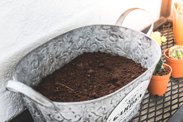 A pot with dirt or soil for planting flower in a small organic garden at home.