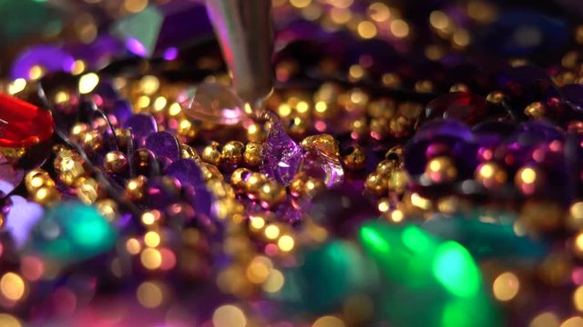 Tip of a glue gun puts hot glue onto sparkling costume and a finger presses a purple rhinestone into place.