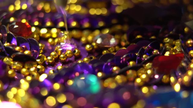 Extreme closeup of hot glue oozing onto a costume and a finger pressing a jewel into place.