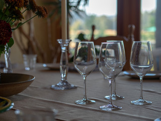Wineglasses and tableware sitting on a table at a family dinner in a home
