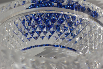 Macro abstract of hand-cut diamond faceted lead crystal glass reflecting bright blue color
