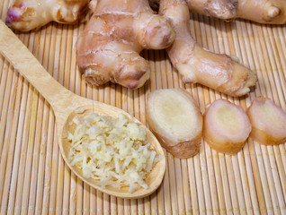 Fresh ginger root and spoon with grated ginger. A healthy product, for colds and for losing weight. Natural medicine.