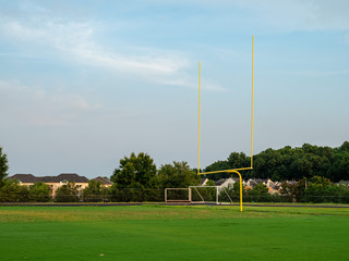 Football goal post at a high school field in the evening sun  - Powered by Adobe