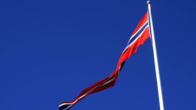 Norwegian flag on the wind with blue sky as a background
