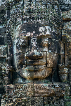 Stone face of Buddha on the tower of the ancient temple of Angkor Tom in Cambodia.