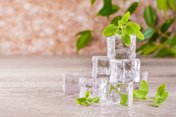 Melting ice cubes and mint leaves on a wooden table