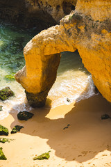 Beach paradise view. Yellow sand and Rocks in the Algarve, Portugal. Nice sunbeam and shadow.